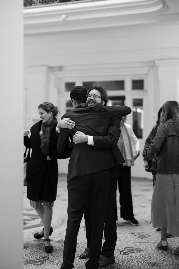 Groom hugging friend before ceremony